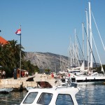 vanaf het terras kun je de boten zien liggen afgemeerd in de haven langs de kade in Starigrad